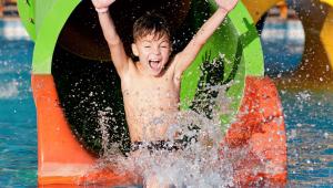 a young boy on a water slide in the water at M Star Columbus North in Columbus