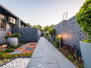 ヨハネスブルグにあるHurlingham House Guest Houseの煉瓦壁の裏庭歩道