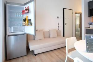 ein Wohnzimmer mit einem weißen Sofa und einem Kühlschrank in der Unterkunft Appartamento Peppino in San Salvo