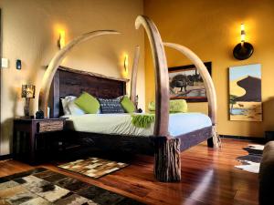 1 dormitorio con 1 cama grande y cabecero abovedado en Phumelo Lodge en Bela-Bela