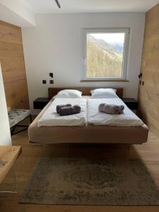 a bedroom with a bed with two pillows and a window at Luxury Mountain Apartment with Private Sauna and Underground Parking in St. Moritz
