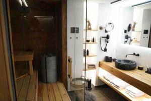 uma casa de banho com um lavatório e uma cabina de duche em vidro. em Luxury Mountain Apartment with Private Sauna and Underground Parking em St. Moritz