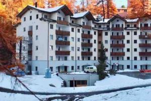 a large white apartment building in the snow at Luxury Mountain Apartment with Private Sauna and Underground Parking in St. Moritz