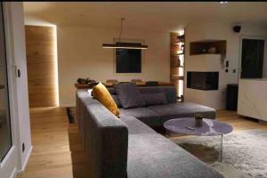uma sala de estar com um sofá e uma mesa em Luxury Mountain Apartment with Private Sauna and Underground Parking em St. Moritz