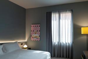 una camera da letto con un letto e una grande finestra di Arryvo Hotel a Lecce