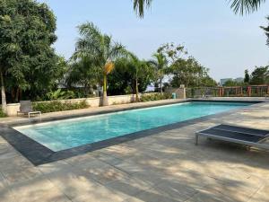 een zwembad met een bankje ernaast bij Modern 2 bedroom Townhouse in Accra in Aiyimensa
