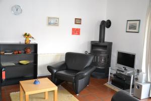 een woonkamer met een stoel en een fornuis bij *Schmitz - Ferienwohnungen in Greetsiel