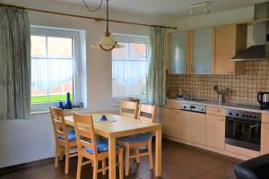 een keuken met een houten tafel en stoelen. bij *Schmitz - Ferienwohnungen in Greetsiel