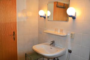 een badkamer met een wastafel en een spiegel bij *Schmitz - Ferienwohnungen in Greetsiel +38 foto's