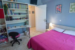 1 dormitorio con cama rosa y escritorio en The Country House, en Preveza