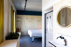 y baño con cama, lavabo y espejo. en hotel Moloko -just a room- sleep&shower-digital key by SMS en Enschede