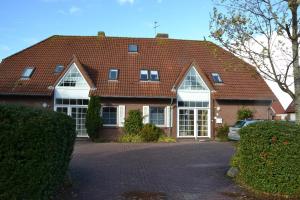 een stenen huis met een rood dak bij *Schmitz - Ferienwohnungen in Greetsiel