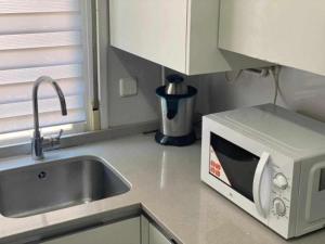 a kitchen counter with a microwave and a sink at Residencia 12 OCTUBRE in Madrid