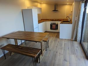 cocina con mesa de madera y nevera en CHALET STANDING Vue mer, en Saint-Raphaël