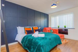 um quarto com uma cama grande e uma parede azul em Luxury Studio Annexe, Heswall em Heswall