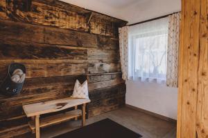 um quarto com uma parede de madeira com um banco e uma janela em Chalet Molly by we rent em Zell am See