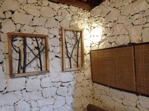 2 ventanas en una pared de piedra en una habitación en Nirankara Nglolang Resort, en Baron