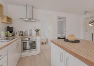 a kitchen with white cabinets and a counter top at Waterfront retreat - 2 BR Boathouse 