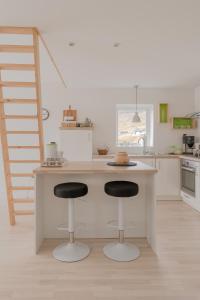 a kitchen with two bar stools at a counter at Waterfront retreat - 2 BR Boathouse 