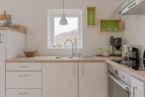 a white kitchen with a sink and a window at Waterfront retreat - 2 BR Boathouse 