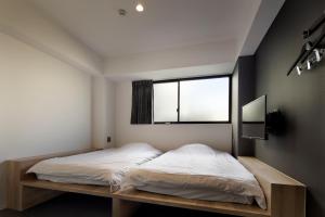 a bedroom with a bed and a window at Piece Hostel Sanjo in Kyoto