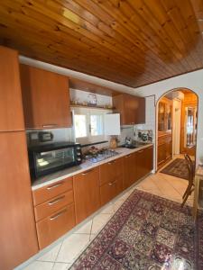 una cocina con armarios de madera y una alfombra grande en La maison des citrons, en Meta
