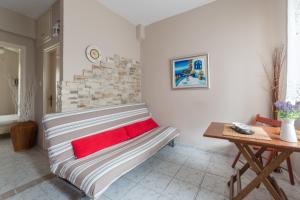 a couch with red pillows in a living room at Cosy Fourka Beachfront apartment in Skála Foúrkas