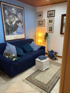een woonkamer met een blauwe bank en een schilderij bij La maison des citrons in Meta