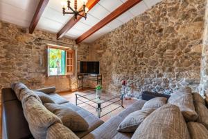 sala de estar con sofá y pared de piedra en Cases de Son Roig, en Sant Joan