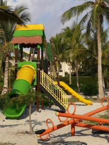 einen Spielplatz am Strand mit Palmen in der Unterkunft Laguna Apartment HAWANA SALALAH Resort in Salalah