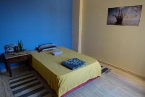 małe łóżko w pokoju z niebieską ścianą w obiekcie SWEET ESCAPE w mieście Al-Kusajr