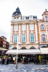 a large building with tables and chairs in front of it at Hotel Industrie in Leuven