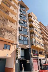 a tall building with a car parked in front of it at Apartamentos Doctor Clara in Castellón de la Plana
