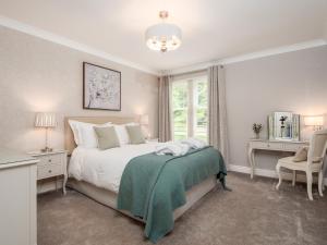 a bedroom with a bed and a chair and a window at Durham Riverside Apartments in Durham