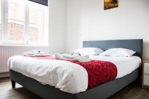 a bedroom with a large bed with a red and white blanket at Hotel Industrie in Leuven