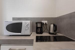 a microwave oven sitting on top of a kitchen counter at LeCosyCannoniersStudio3 in Grand Baie