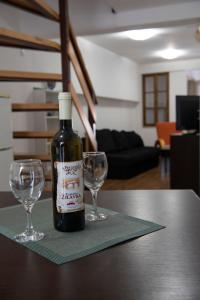 Eine Flasche Wein steht mit zwei Weingläsern auf einem Tisch. in der Unterkunft Mare Stari grad in Trebinje + 4 Fotos