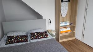 1 dormitorio con 1 cama con 2 almohadas en Apartamenty Piaskowe, en Rowy
