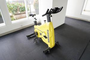 uma bicicleta de exercício amarela estacionada num quarto em Series Hotel Sudirman em Jakarta