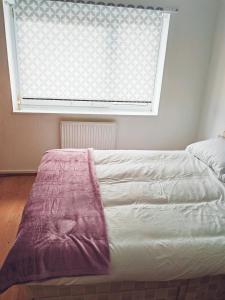 a bed in a bedroom with a large window at holiday home in Manchester