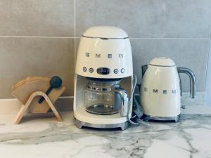 a white coffee maker sitting on top of a counter at Apartamentos Noja Playa in Noja