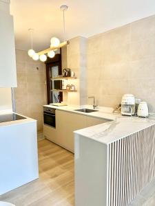 a kitchen with white counters and a counter top at Apartamentos Noja Playa in Noja