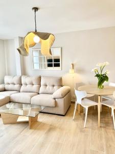 a living room with a couch and a table at Apartamentos Noja Playa in Noja