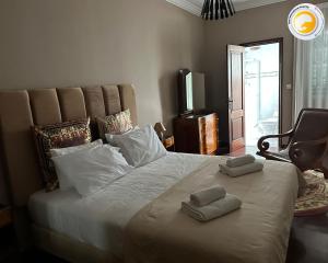 a bedroom with a large bed with two towels on it at Azor International House in Ponta Delgada