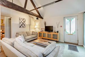 a living room with two couches and a tv at 2 Bed Barn conversion in Tibenham