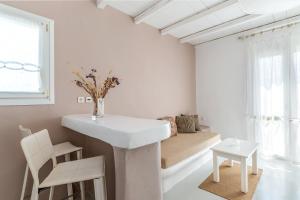 キオニアにあるNinemia Suites Tinos Grand 205の白いバスルーム(シンク、ソファ付)
