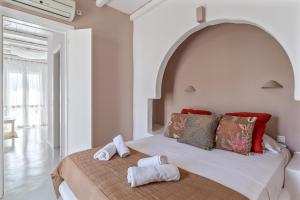 キオニアにあるNinemia Suites Tinos Grand 205のタオルが敷かれたベッドのある寝室