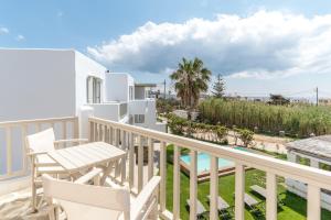キオニアにあるNinemia Suites Tinos Grand 205のバルコニー(テーブル、椅子、プール付)