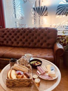 una mesa con pan y una cesta de comida en un sofá en Enzo Hotels Limoges Centre Jourdan by Kyriad Direct, en Limoges