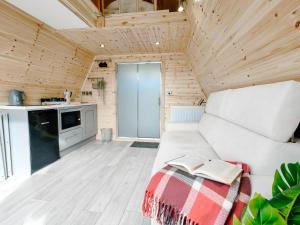 a living room with a white couch and a kitchen at Bective Mill Glamping & Camping 